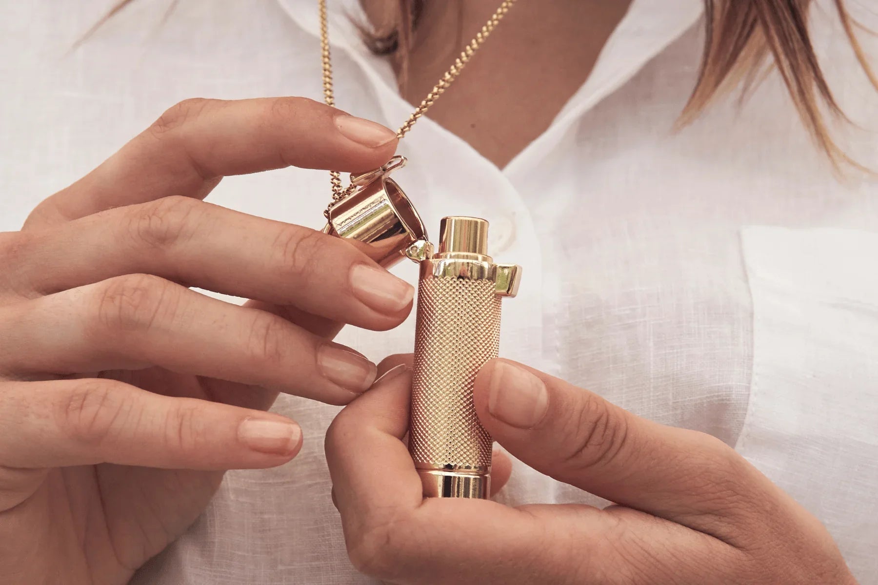Woman opening her St Tropez Gold Pendant by Veronique Gabai