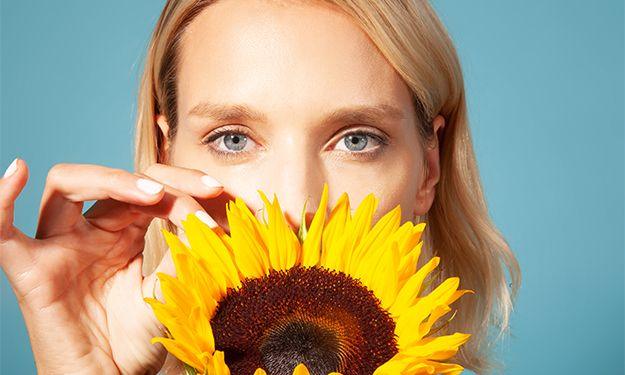 Woman with a large sunflower covering her face, representing possible personality's of perfumes. 